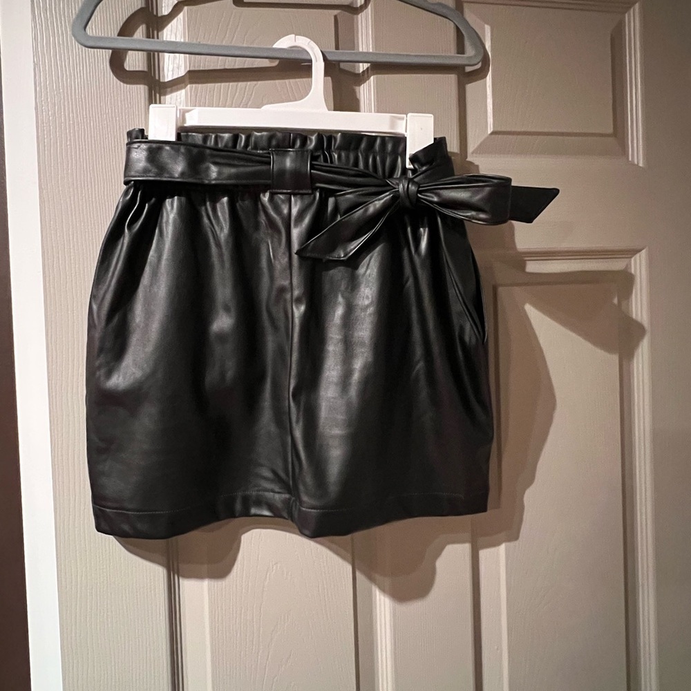 Black faux fur mini skirt. Cute matching bow belt. Size Medium.